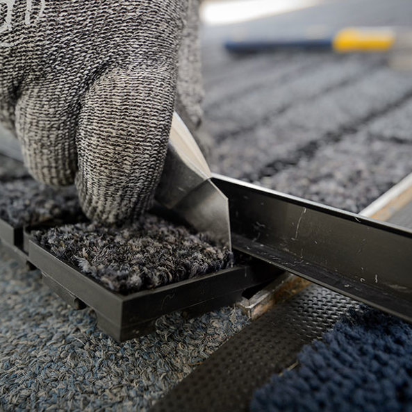 Commercial entrance mat being fitted by phs employee