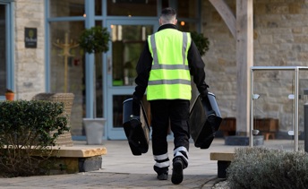 phs worker carrying sanitary bins